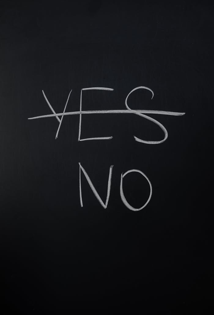 Handwritten chalk decision concept with yes crossed out and no emphasized.